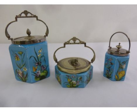 Three polychromatic ceramic biscuit barrels with silver plated covers and swing handles