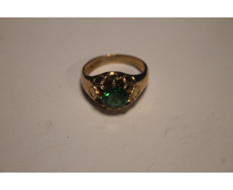 A 9CT GOLD RING SET WITH A GREEN STONE W 6 GR