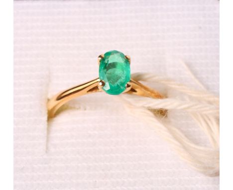 A single stone emerald ring on 18ct gold shank