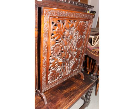 A wooden firescreen carved and pierced floral designs, 25" wide, and a mahogany rectangular occasional table, fitted undershe