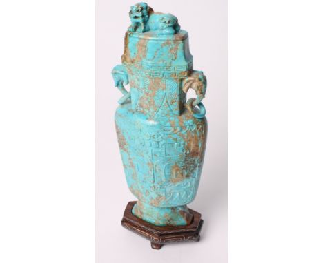 A 19th Century Chinese carved turquoise vase of flattened form, sides carved stylised dragons, elephants' head and ring handl