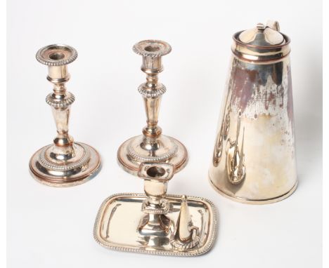 An Arts & Crafts style silver plated hot water jug, a pair of plated candlesticks and a plated chamber stick