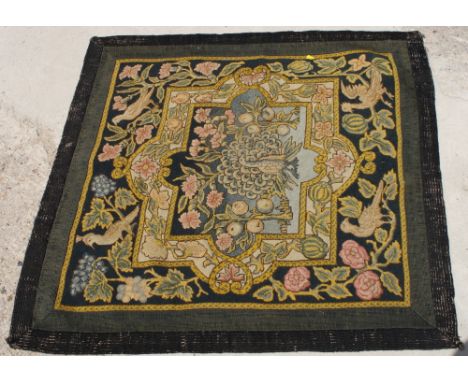An Arts & Crafts tapestry panel decorated central peacock with flower and bird decorated border, 40" x 38"