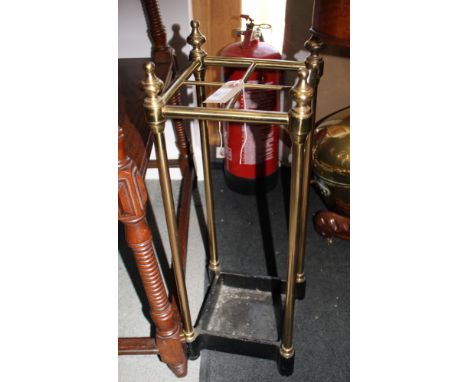 An Edwardian tubular brass stick stand on cast iron base, 9" dia