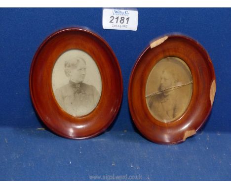 A pair of oval believed cherry wood framed sepia photographic Portraits of a bearded gentleman and a lady in early dress, tha