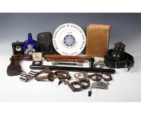 A collection of 19th and 20th century police memorabilia, including a set of leg iron shackles, a set of figure-of-eight hand
