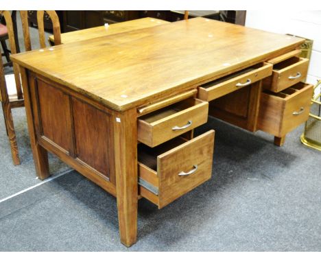A large light oak office desk, rectangular top, an arrangement of five drawers and two slides. 77cm high x 152cm wide x 90cm 