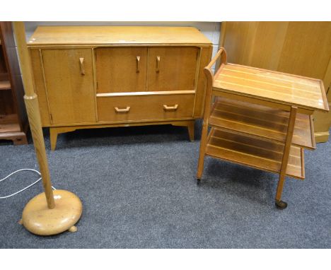 A mid 20th century light oak  G-Plan sideboard; a G-Plan style serving trolley; a light oak and teak standard lamp (3)