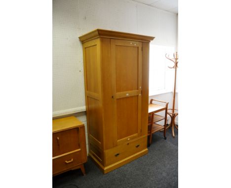 A contemporary light oak single wardrobe, ogee cornice, panelled door above long drawer, plinth base 