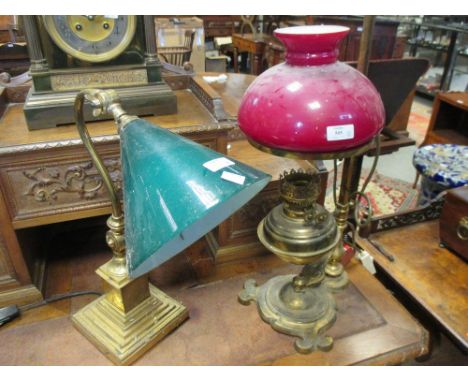 A decorative brass adjustable table lamp, converted for electricity and another brass desk lamp with green glass shade (2)  