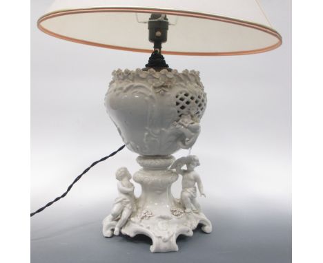 A white porcelain lamp base decorated with putti and flowers with shade  