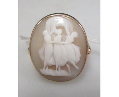 A shell cameo depicting the three graces, set in a yellow metal ring  
