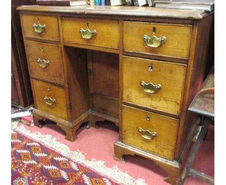 A George III elm kneehole desk, fitted drawers around a cupboard to the kneehole, on bracket feet, 81cm high x 101cm wide x 4