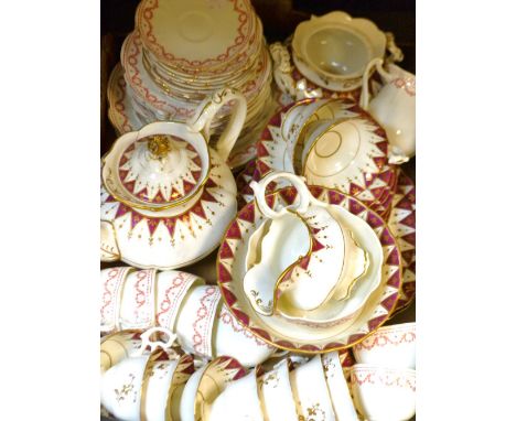 A Staffordshire tea service decorated with a red and gold garland border, comprising, cake plates, tea pot, tea cups, saucers