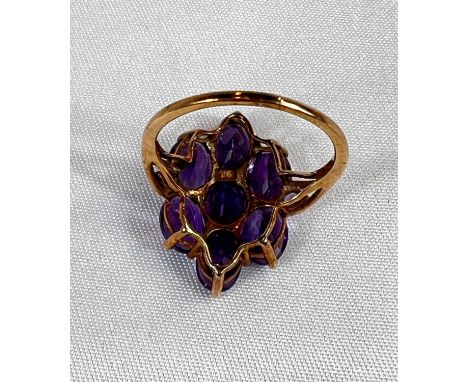 A 9 carat gold dress ring set with amethyst coloured stones