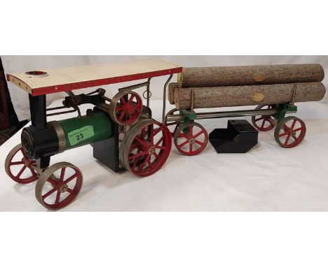 A Mamod Steam powered traction engine and trailer with logs.