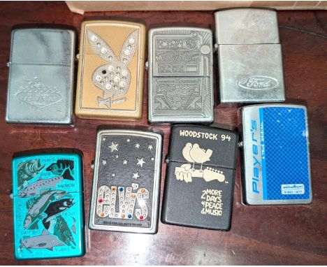 Eight Zippo lighters, various designs.