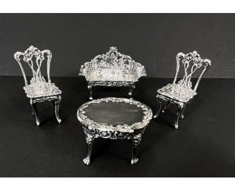 A suite of hallmarked silver miniature furniture comprising ornate settee, two Chippendale style chairs and oval table, Birmi