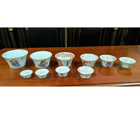 An unusual set of Chinese stacking bowls each with polychrome decoration and characters, seal mark to base, largest diameter 