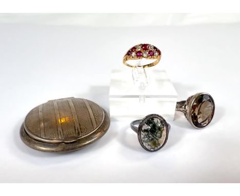 A yellow metal dress ring set with diamonds and rubies, two white metal dress rings and a compact