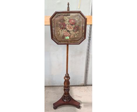 A 19th century mahogany pole screen with floral tapestry picture in canted glazed square.