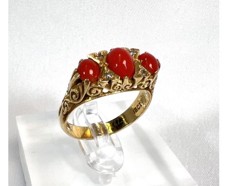 A Victorian or Edwardian 18ct gold dress ring set 3 coral cabochons and 4 tiny diamonds, 6.8gm gross.