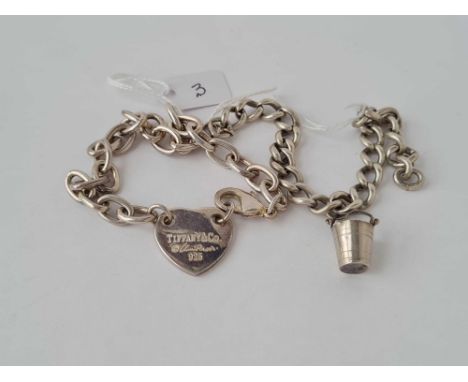 A white metal link bracelet with silver bucket charm inc a white metal bracelet with heart shaped clasp marked Tiffany and Co