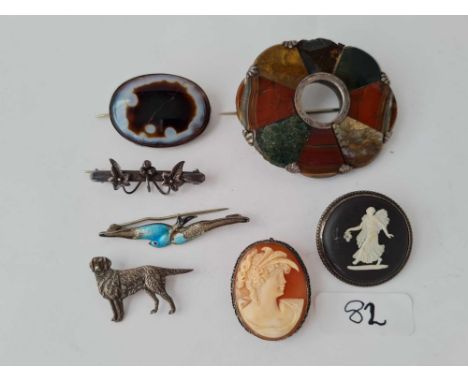 A bag containing seven silver mounted brooches