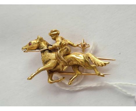 A UNUSUAL DESIGNER BROOCH OF A PONY WITH RUBY EYE AND RIDER APPEARING TO HURL A BALL IN 18CT GOLD - 9.2 GMS