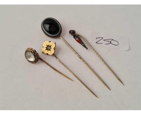 Four assorted stick pins including moonstone and banded agate examples 