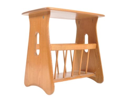 An Ercol contemporary Windsor range blond elm wood magazine table. Pebble style tabletop with magazine rack to underside, rai