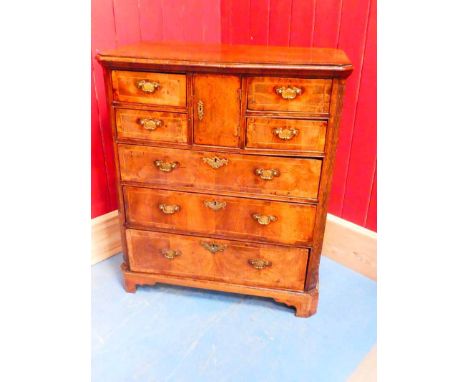 A George II walnut bachelors chest, the central pigeonhole cupboard is flanked by four small drawers and surmounts three furt