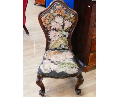 A Victorian nursing chair in rosewood with tapestry cover