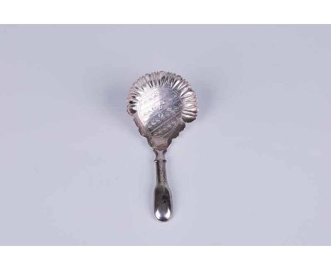 A Regency silver caddy spoon with hollow handle and brightcut guilloche decoration in the serpentine edged bowl, Birmingham 1