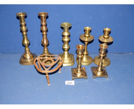 Three pairs of brass candlesticks including square based, wide drip trays and baluster together with a single candlestick and