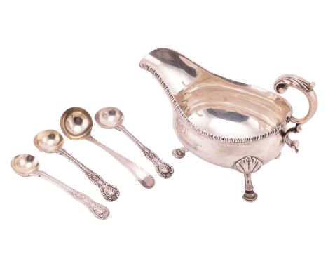 A George III silver sauce boat, with gadrooned border, leaf-capped flying double scroll handle, and on three shell mounted st