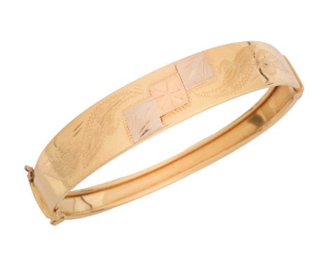 A hinged bangle with bright-cut foliate engravings, tapered halves fastened with a concealed tongue clasp and safety chain, t