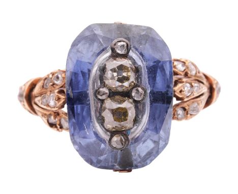 A sapphire and diamond dress ring, featuring a centrally carved cushion-cut sapphire of 13.6 x 9.5 mm, superimposed with a cl