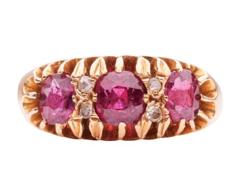 A ruby three-stone ring, claw-set with three slightly graduated oval-cut rubies, interspersed by duos of rose-cut diamonds, m