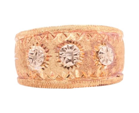 A dress ring of tapered and textured design, overlaid to the front with three starbursts, between reeded borders, to a polish