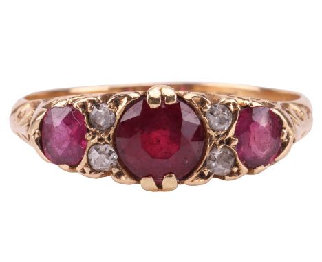 An Edwardian ruby and diamond half-hoop ring in 18ct gold, comprising three graduated circular-cut rubies, the central one ha