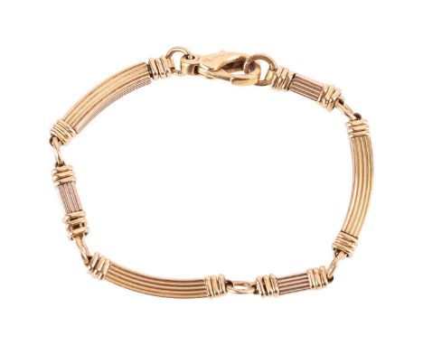 Boucheron - a two-tone link bracelet in 18ct gold, of ridged design, alternating with white and yellow gold bar links, comple