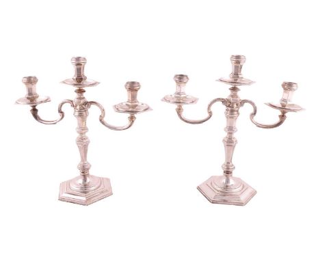 A pair of early 18th century style three light candelabra; panelled hexagonal form with detachable scrolling arms, baluster s