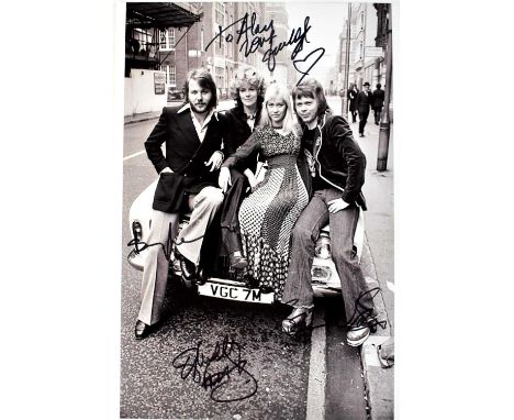 ABBA; a black and white promotional photograph, bearing the signatures of the band, 30 x 21cm.Condition Report: We have not a