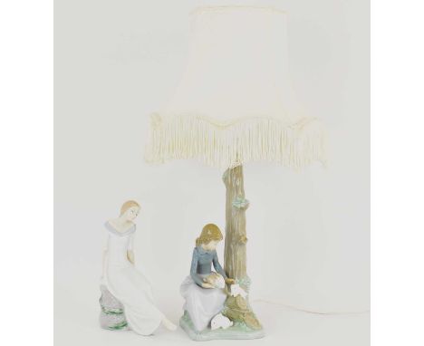 NAO; a porcelain table lamp with girl and rabbit to the base, height to top of shade 53cm and a porcelain figure of a girl re
