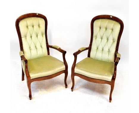 A pair of reproduction mahogany framed open arm elbow chairs with upholstered seat and button pressed back, raised on slender