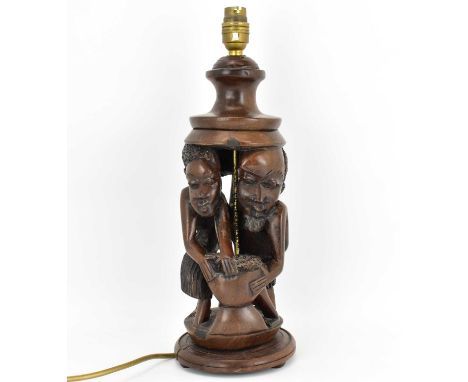 An early 20th century carved wood table lamp with two African figures to the middle, height 39cm.