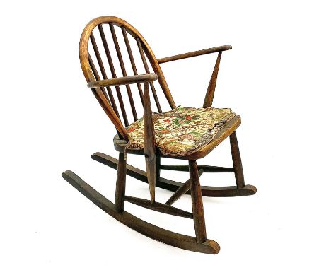 An Ercol type elm and beech low rocking chair With stick back and solid seat, height 74cm, width 60.5cm, depth of rockers 73c