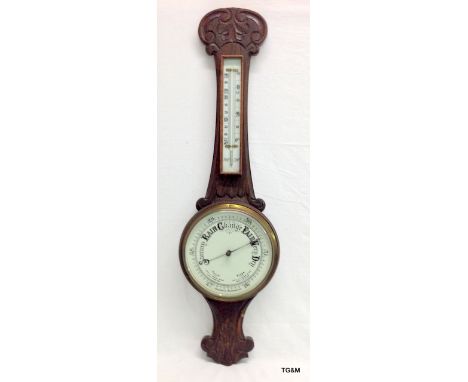 An oak cased Aneroid barometer and thermometer, 83cm long, dial 20cm diameter