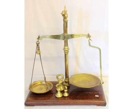 A vintage W and T Avery pair of large brass balance scales with bell weights on a wooden base 59cm high